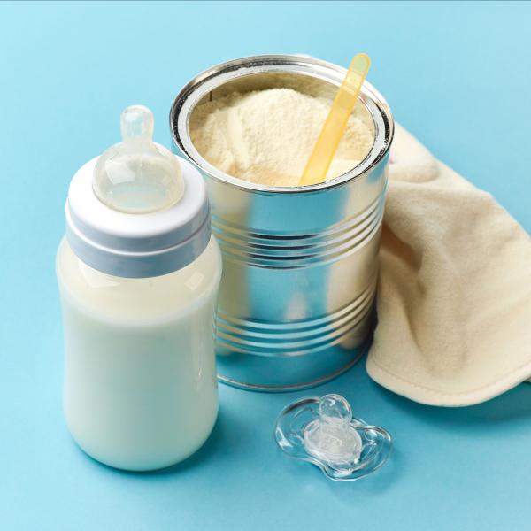 Bottle alongside a scoop of Glanbia Ireland Ingredients Infant Grade Whole Milk Powder