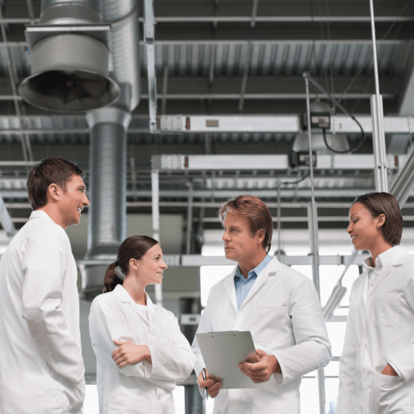 image of four lab workers in lab coats, in conversation